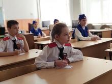 В классе сидят дети в школьной форме с красными погонами.