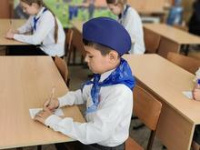 Мальчик в белой рубашке и синей пилотке с шарфом проходит испытание по ПДД