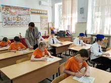 В классе дети в оранжевых футболках и белых рубашках с синими фуражками проходят испытание "Медицина"