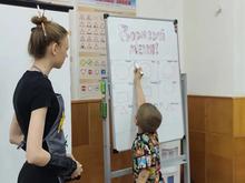 На изображении женщина и ребёнок стоят у доски с надписью «Дорисуй меня!». Педагог смотрит на доску, ребёнок рисует.
