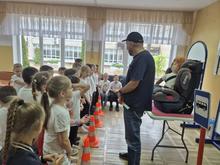 В комнате дети стоят в ряд, слушают инструктора. На столе детское кресло