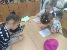девочки выполняют задания на листочках